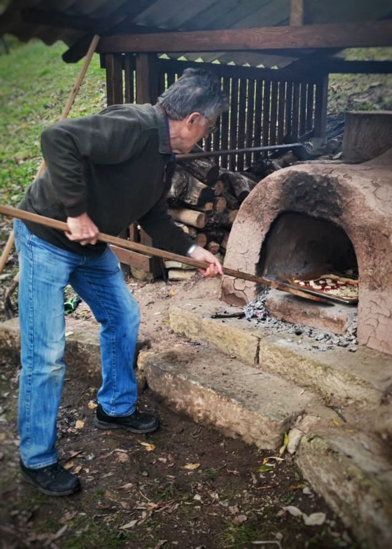 Pizza wird in den Pizza-Lehm-Ofen geschoben